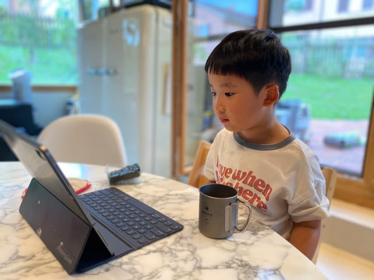 A child focused on a learning activity at the kitchen table